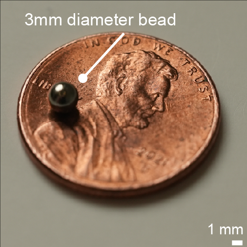 Three-millimeter magnetic bead resting on a penny for scale